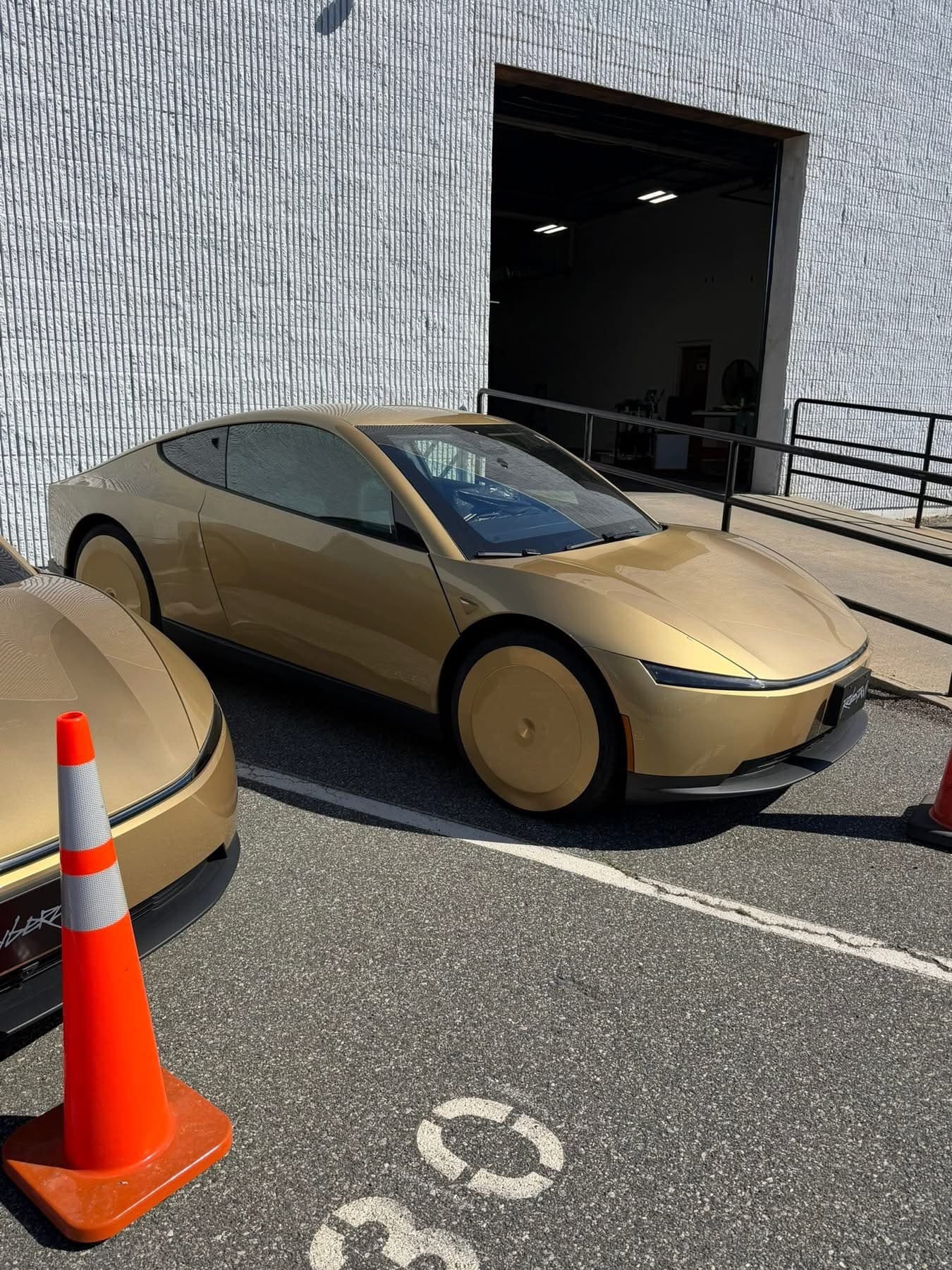 Front three-quarter view of gold-camo Tesla Cybercab test units at Tesla Peabody